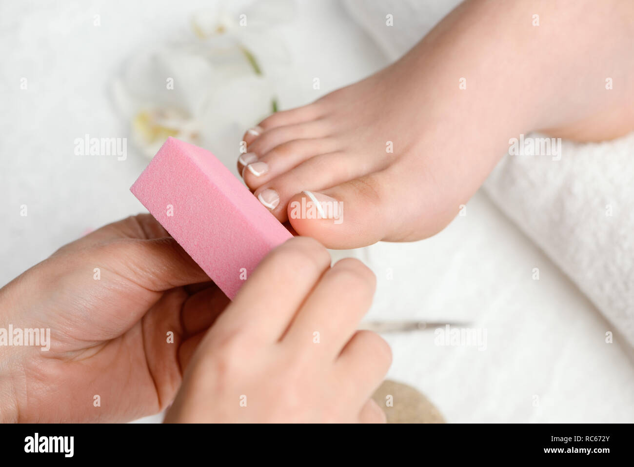 Pedicurist polishing toe nails Stock Photo