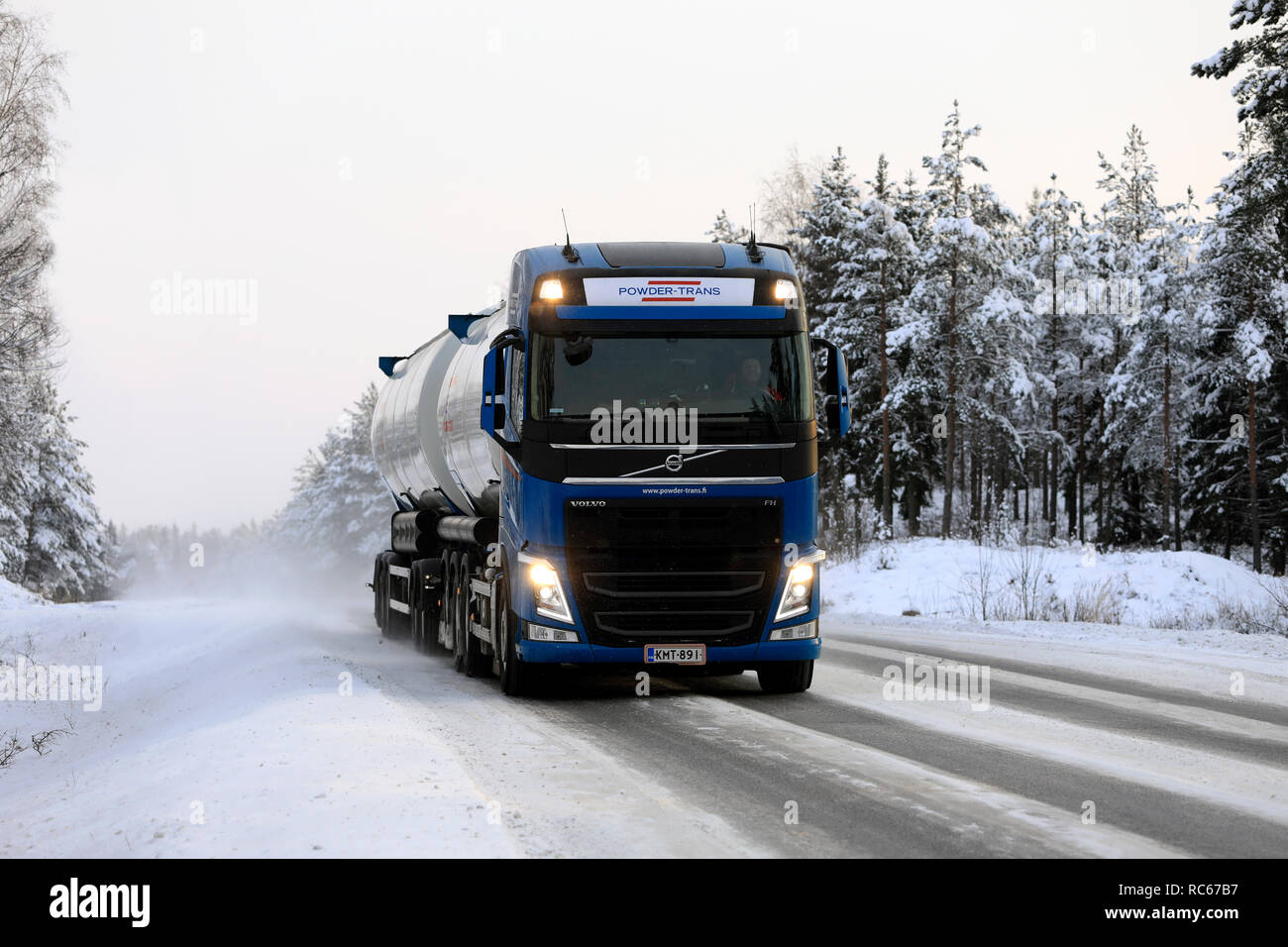 Salo, Finland - December 23, 2018: Volvo FH bulk transport truck up front driving on snowy road in arctic conditions, with high beam lights on briefly Stock Photo
