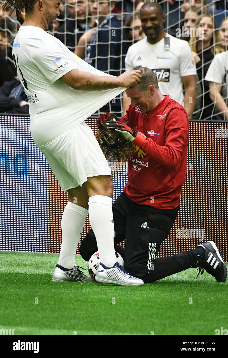 Gummersbach, Germany. 13th Jan, 2019. Schauinsland Reisen Cup: The singer Mickie  Krause puts on his wig under the jersey of Patrick Owomoyela at the  celebrity game of the indoor soccer tournament. Credit: