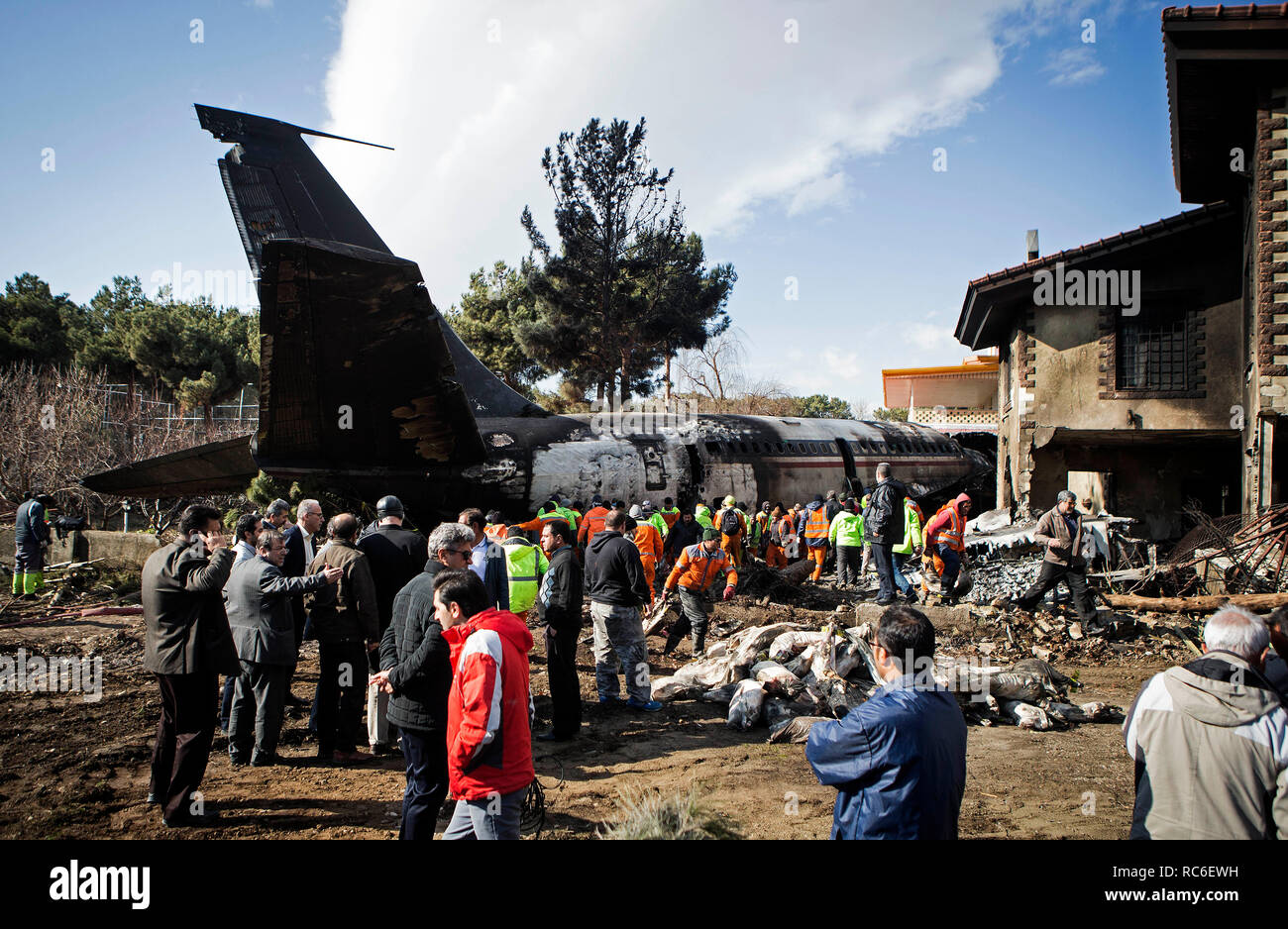 Karaj, Iran. 14th Jan, 2019. Rescuers work at the crash site of a Boeing 707 plane in Karaj, Iran, Jan. 14, 2019. At least 15 people were killed on Monday in the crash. Credit: Ahmad Halabisaz/Xinhua/Alamy Live News Stock Photo