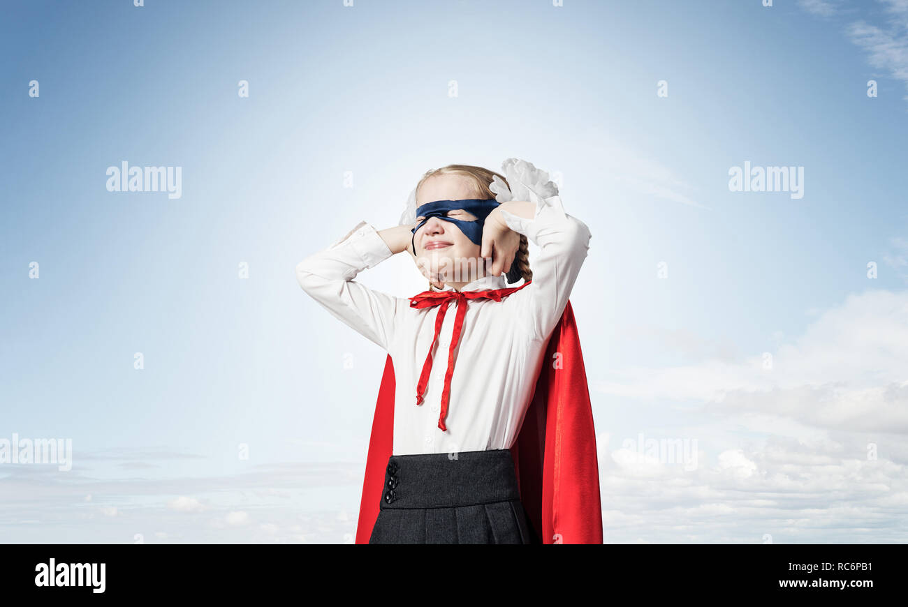 Kid girl superhero against cityscape background annoyed by sound Stock Photo