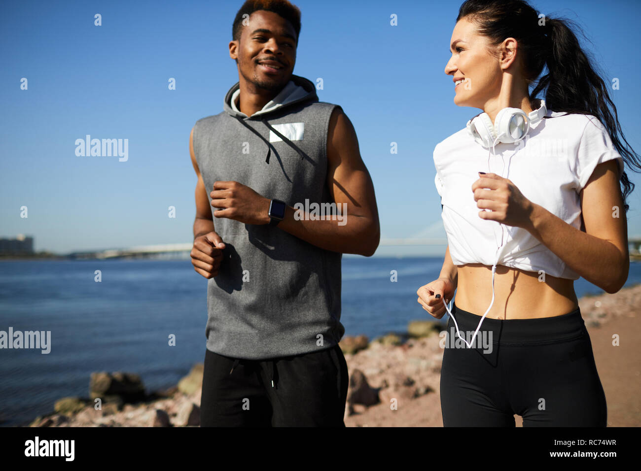 Positive couple running over beach Stock Photo