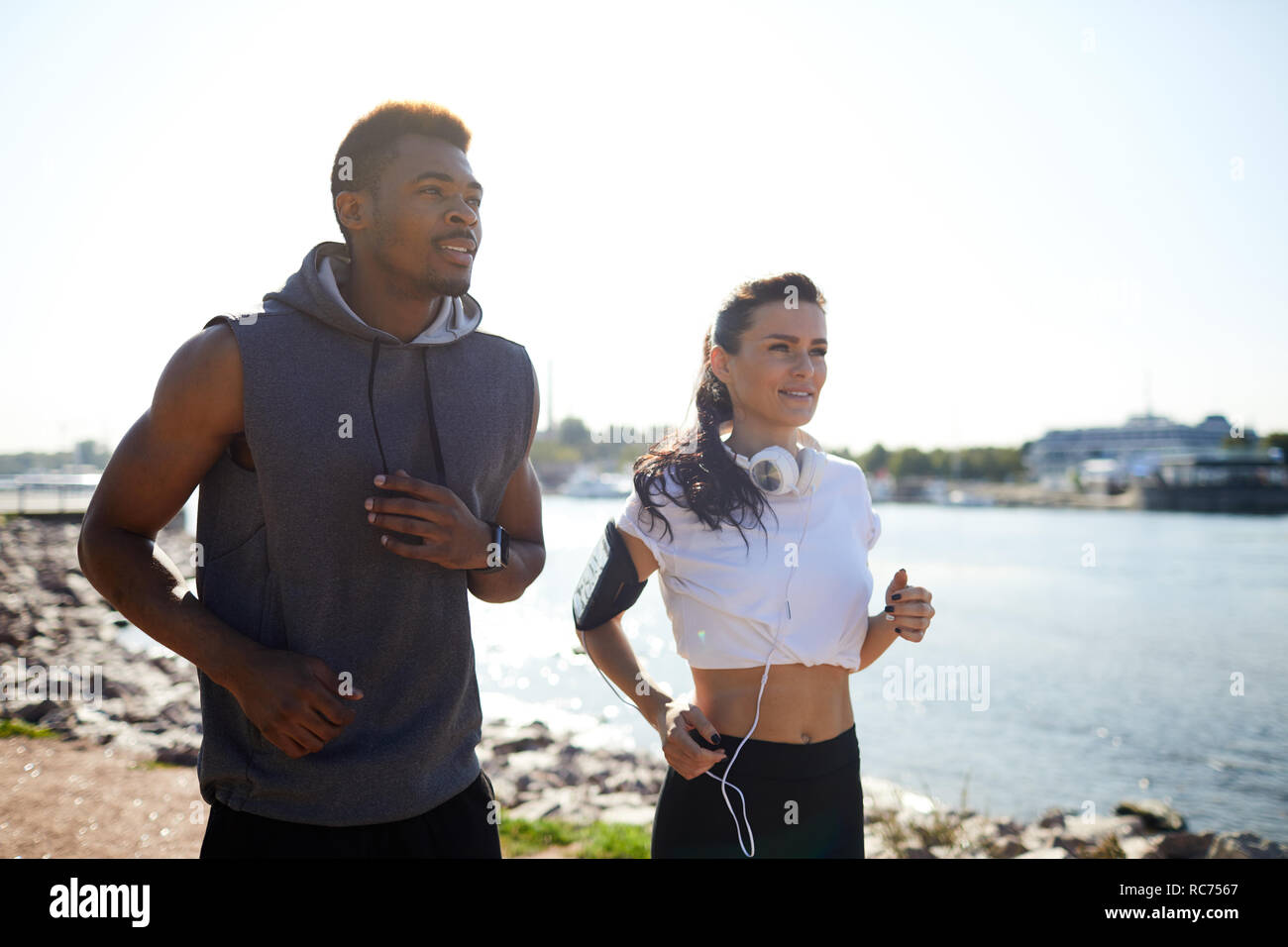 Jolly interracial joggers on coast Stock Photo