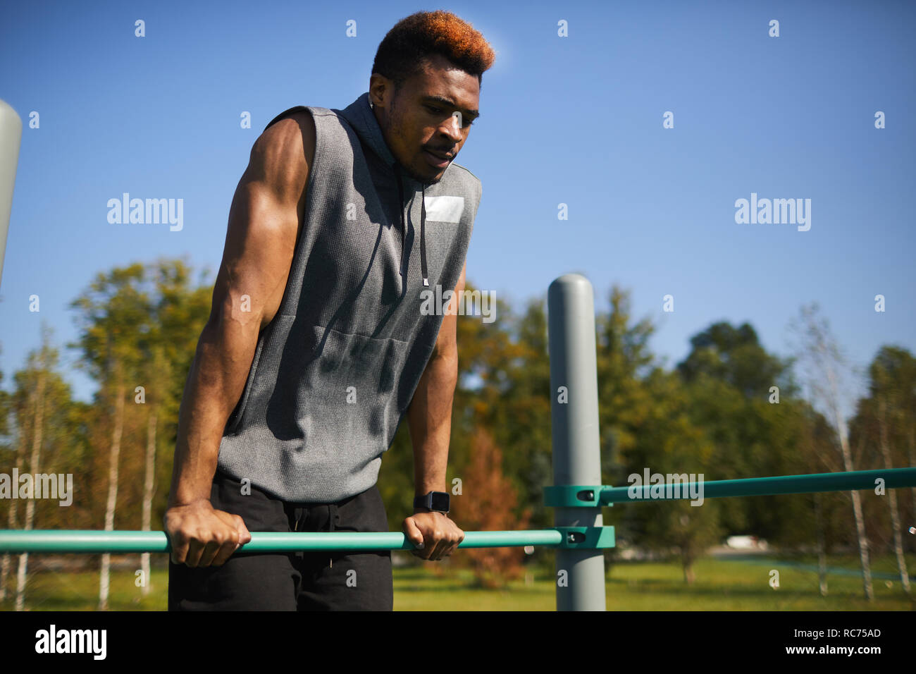 Doing dips at sports ground Stock Photo
