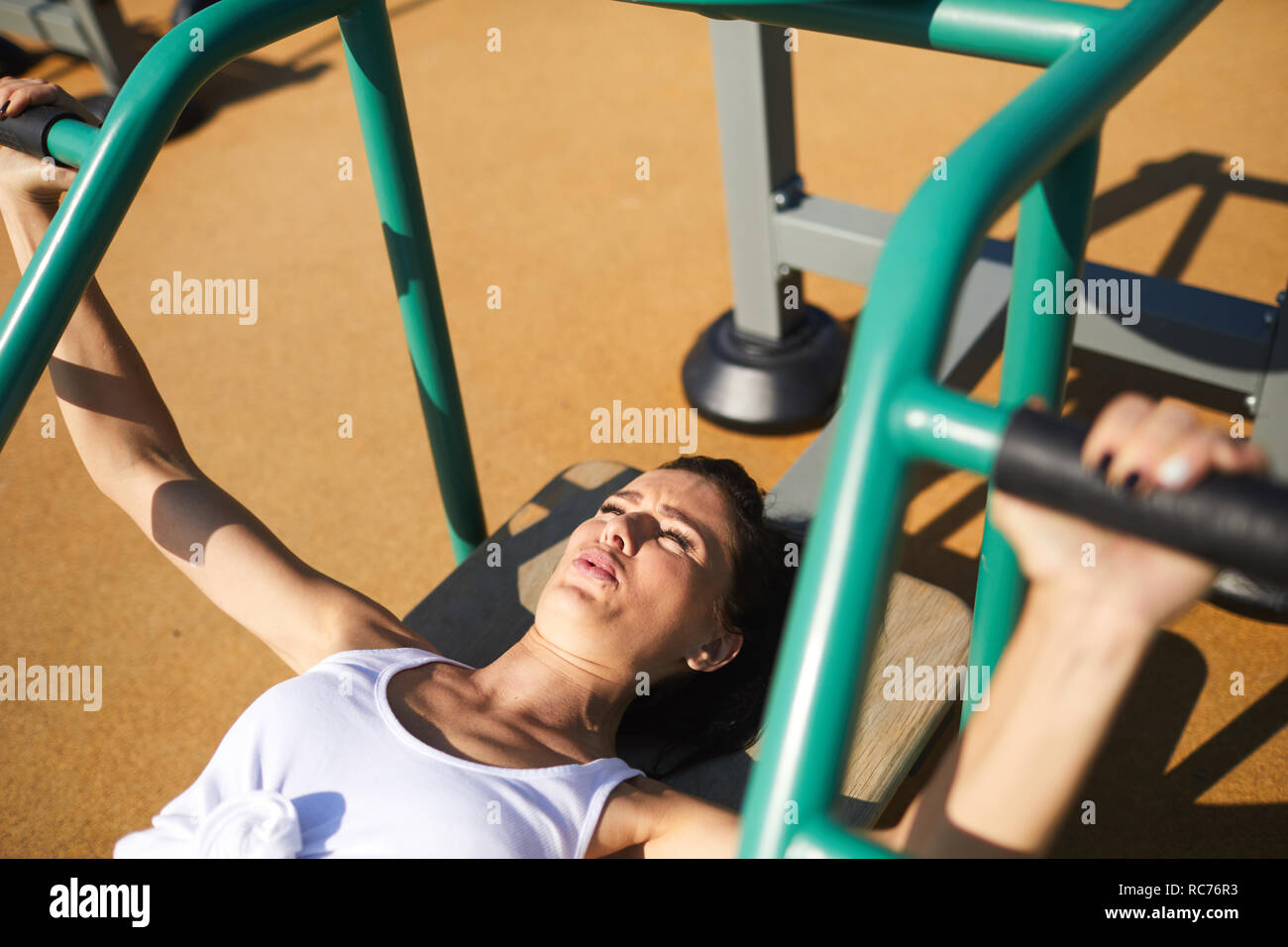 Strong Woman Performing Barbell Bench Press Outdoors Stock Photo