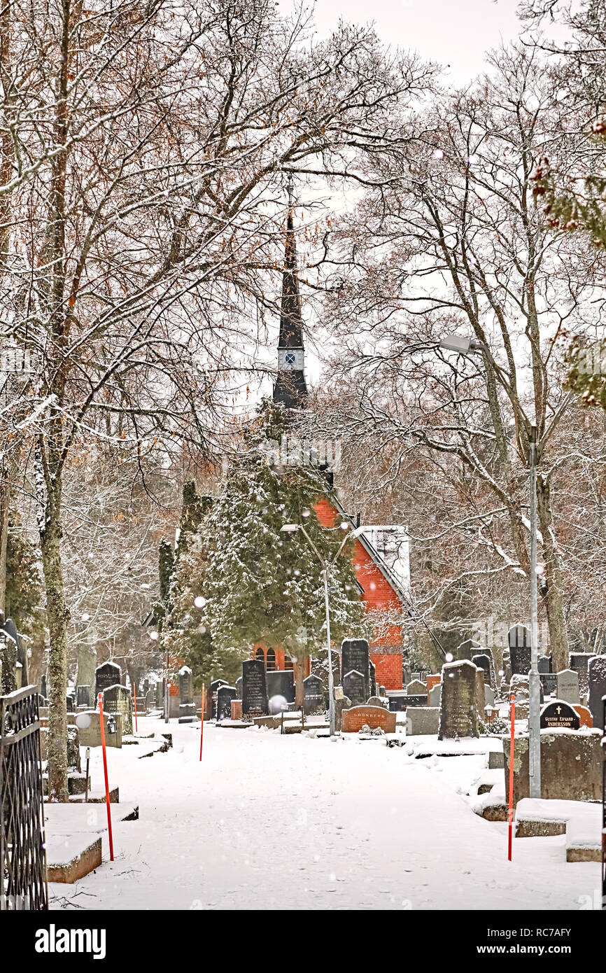 Porvoo, Finland - December 25, 2018: old town cemetery grave yard with Finnish Kirche church with winter snow. Stock Photo