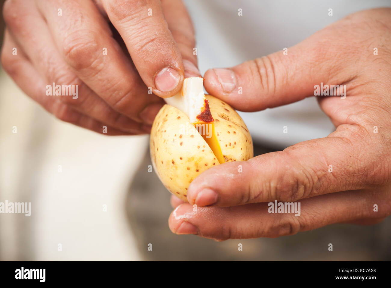 Stuffing potatoes with smoked lard, hands of cook close-up photo with selective focus Stock Photo