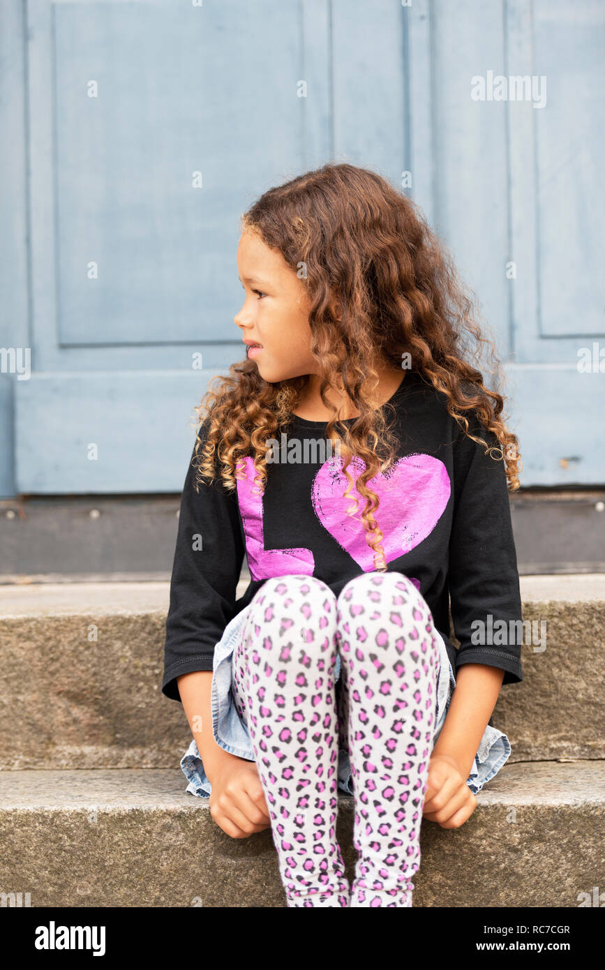 Little girl sitting on stairs Stock Photo - Alamy