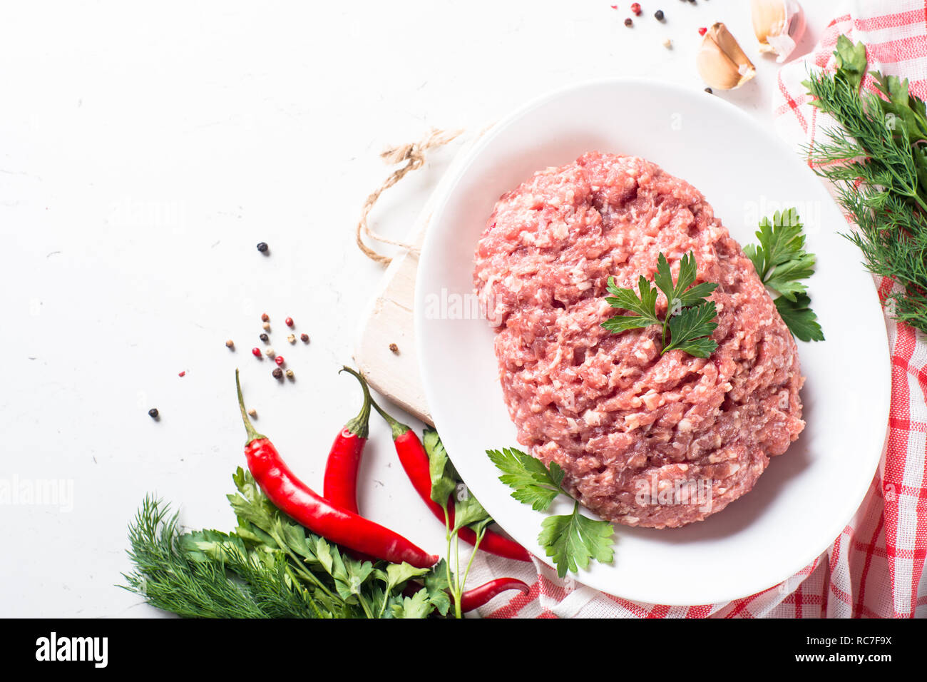 Minced meat with ingredients for cooking on white table. Top view with