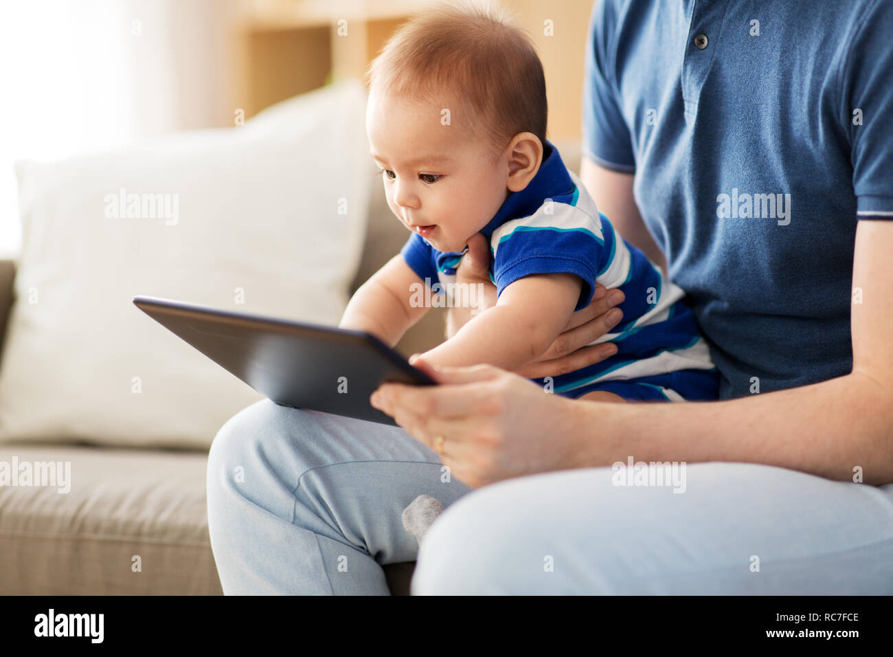 baby and father with tablet pc at home Stock Photo