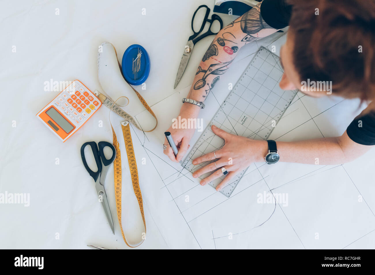 Fashion designer drawing and creating dressmaker's pattern Stock Photo
