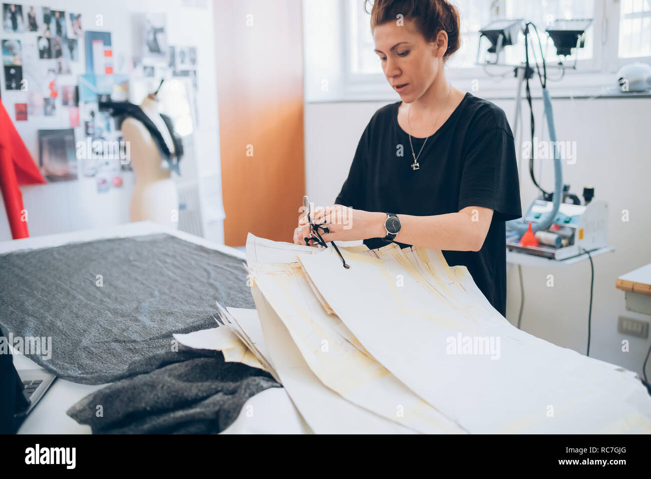 Fashion designer laying out dressmaker's pattern Stock Photo
