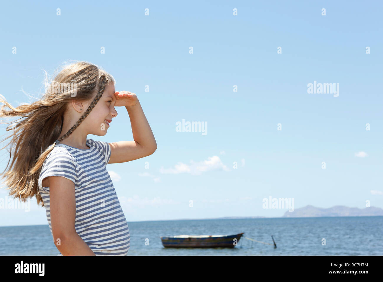 Girl with long blond hair looking out from beach, Trapani, Sicily, Italy Stock Photo