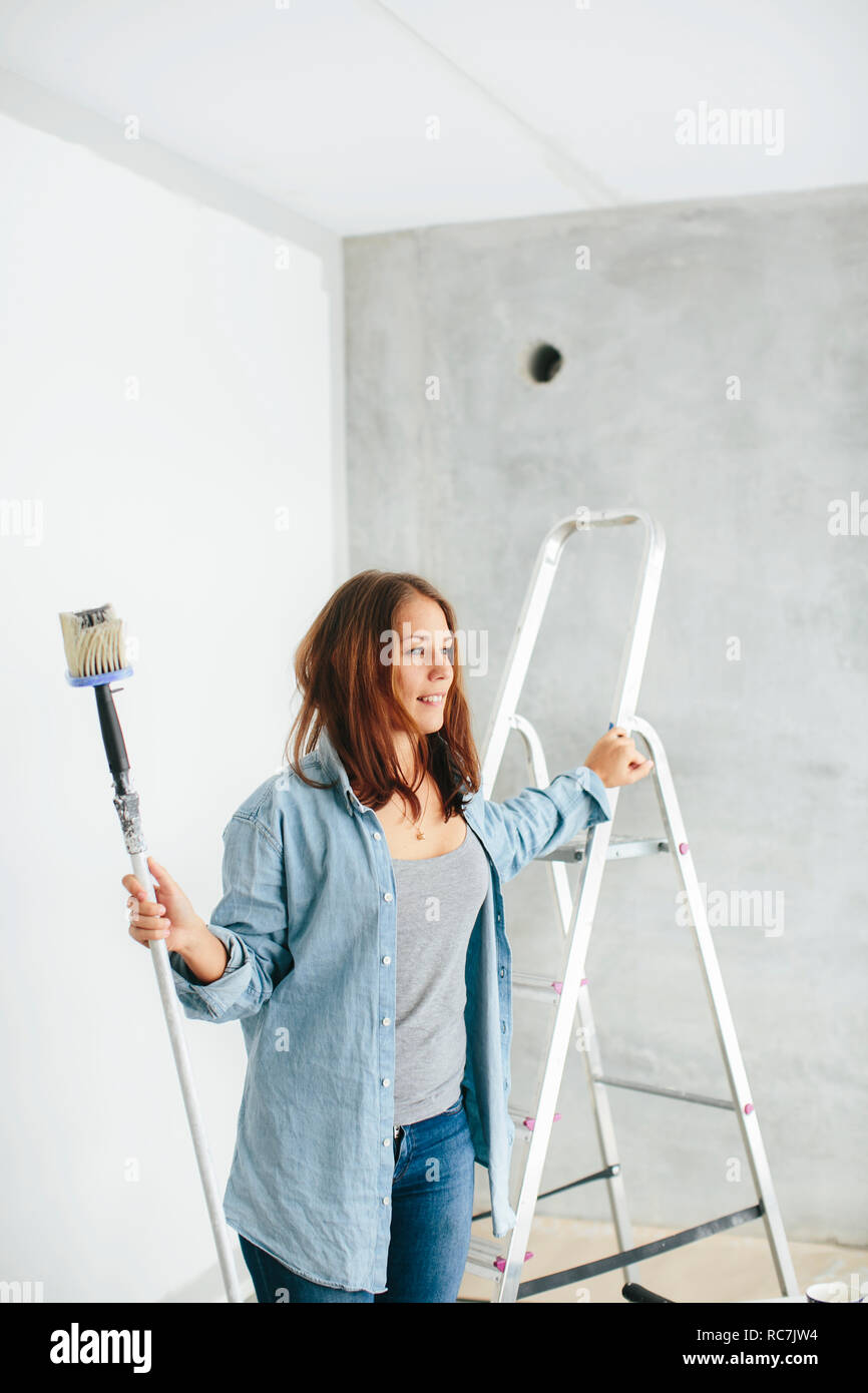 Woman paints white wall paint hi-res stock photography and images - Alamy