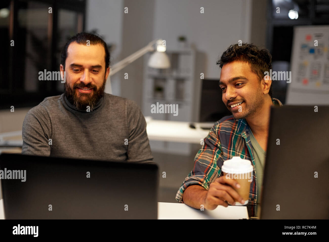 creative team drinking coffee at night office Stock Photo