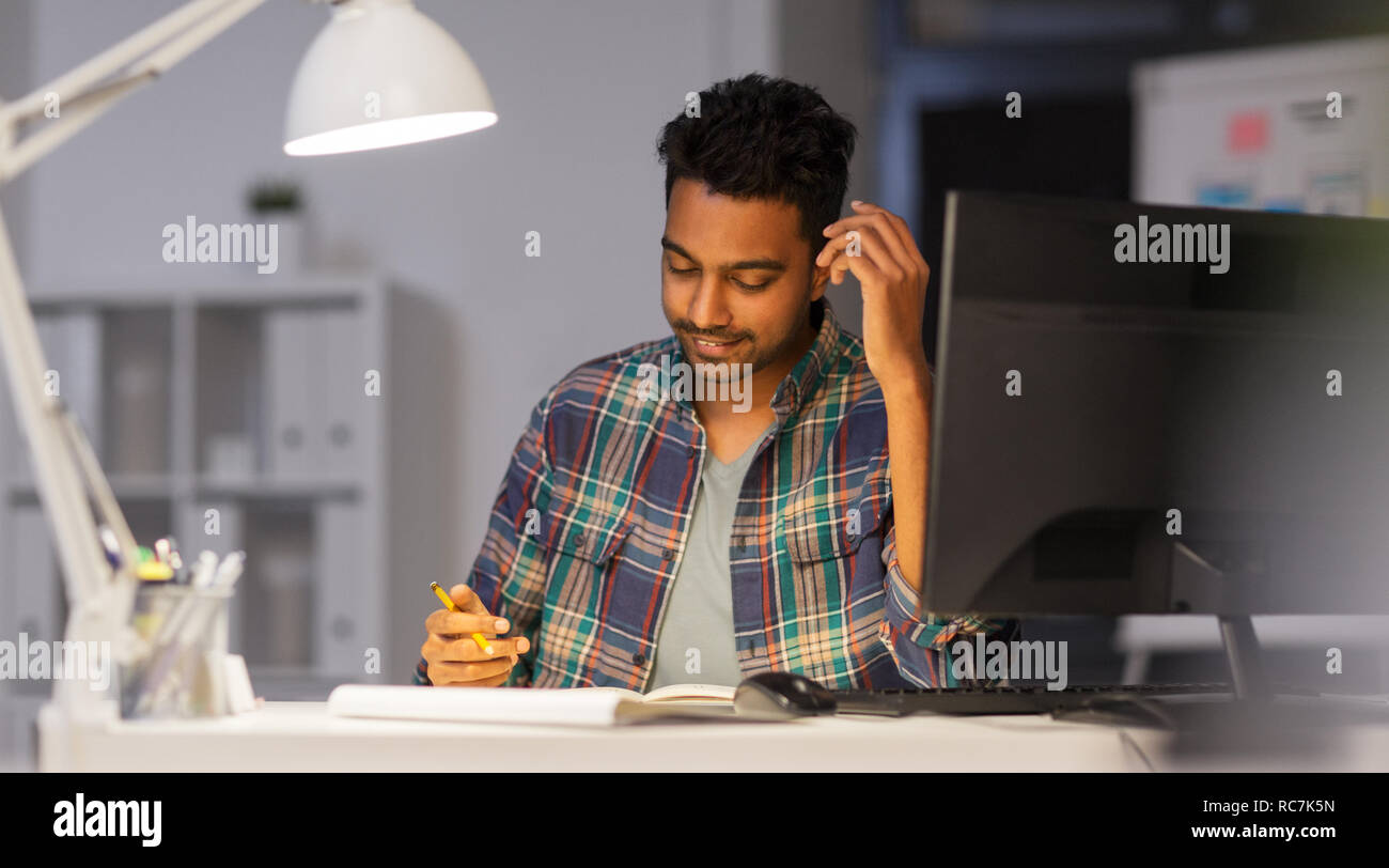 creative man with notebook working at night office Stock Photo