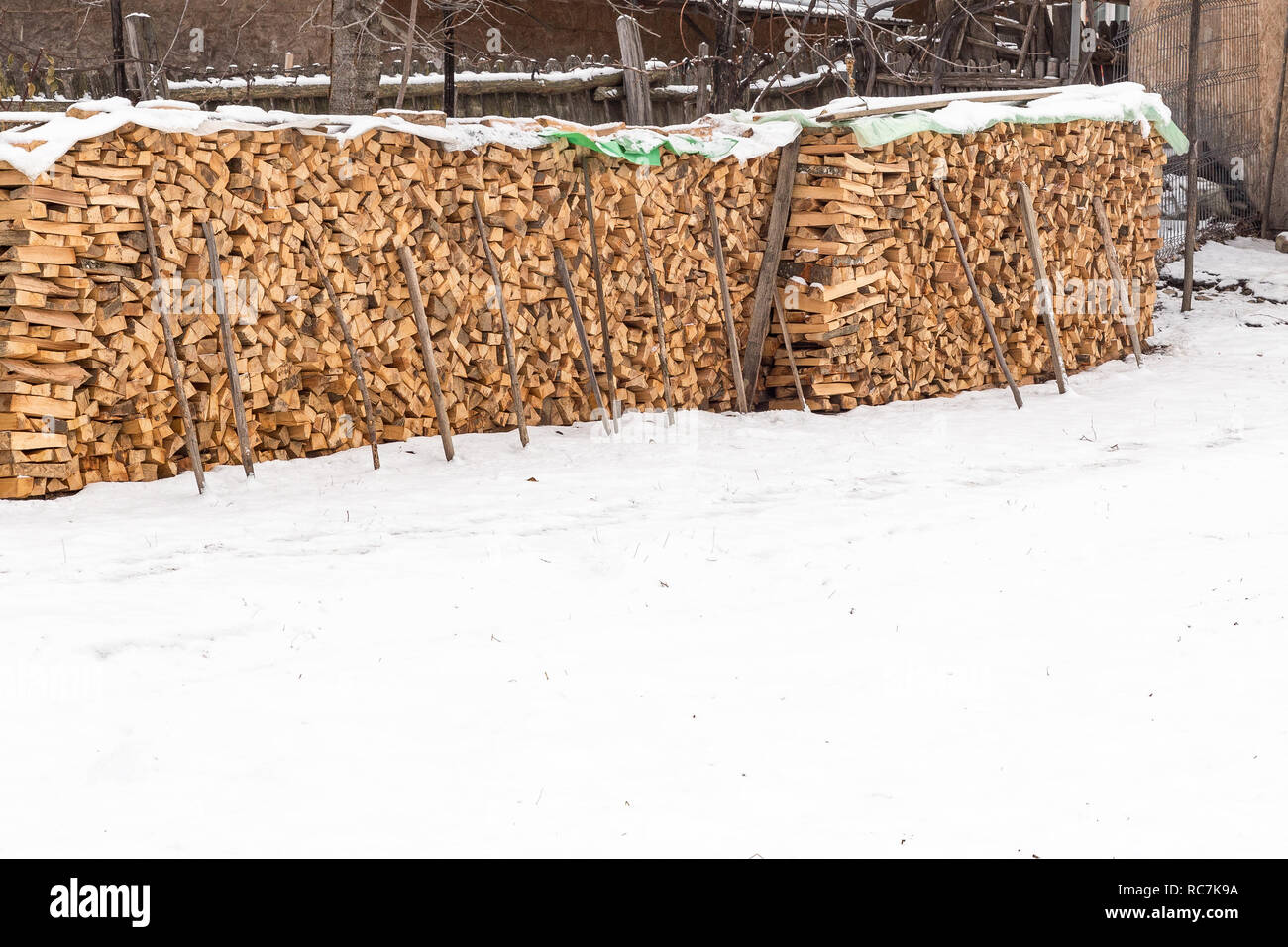 Dry chopped firewood logs stored outside. Dry chopped firewood logs ready stacked out on a snowy day. Stock Photo