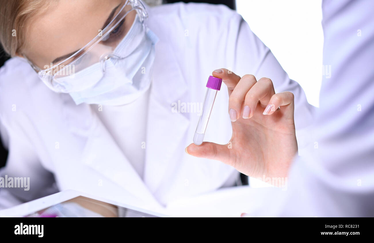 Closeup of scientific research team with clear solution in laboratory ...