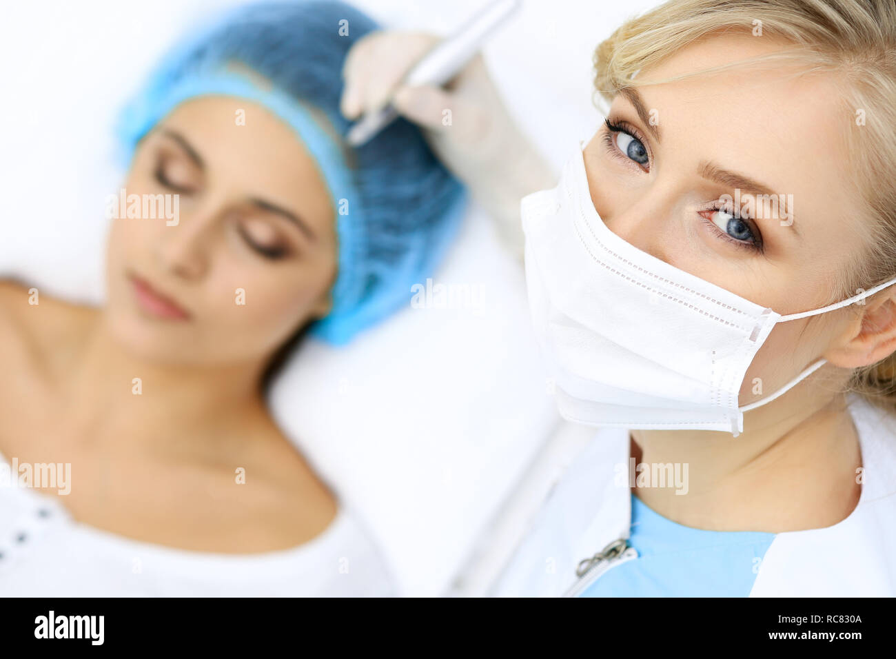 Professional beautician doing eyebrow tattoo at woman face. Permanent