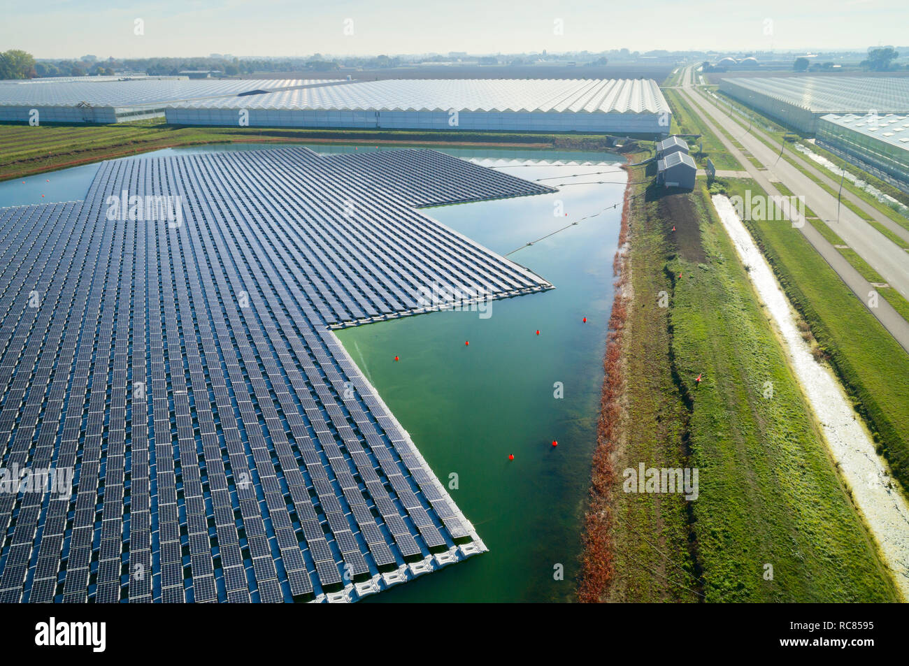 Floating solar panels installed on water supply of neighbouring greenhouses, elevated view, Netherlands Stock Photo
