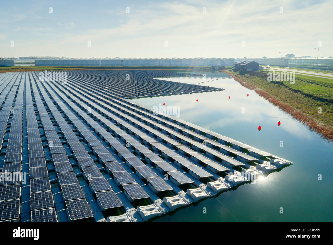 Floating solar panels installed on water supply of neighbouring greenhouses, elevated view, Netherlands Stock Photo