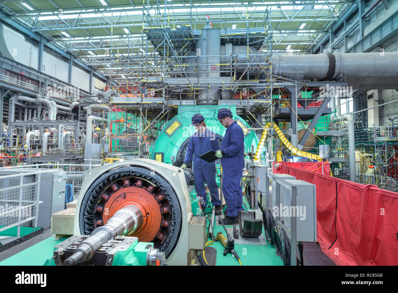 Engineers inspecting gears at generator end in nuclear power station during outage Stock Photo