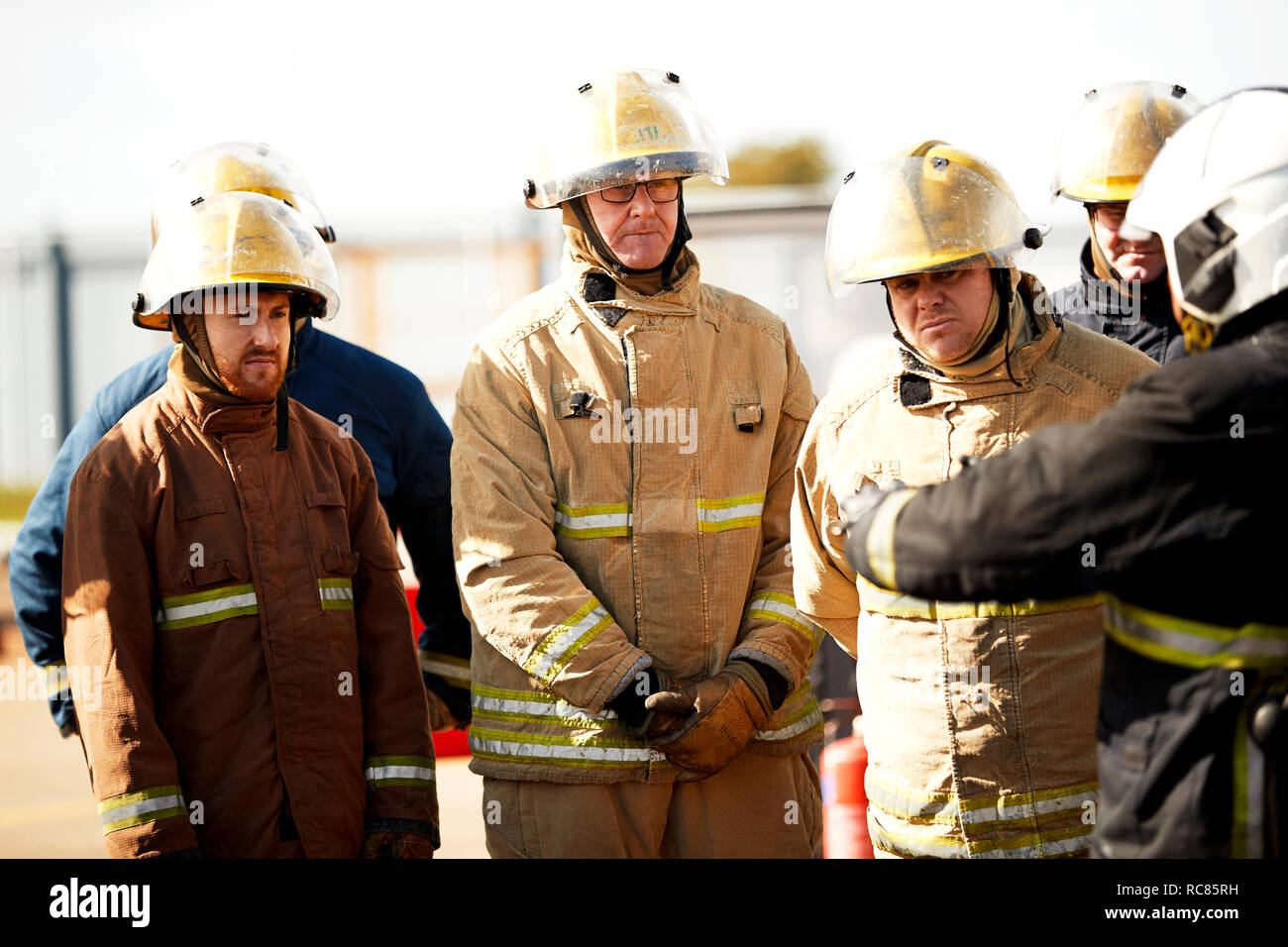 Firemen training, firemen listening to supervisor at training facility Stock Photo
