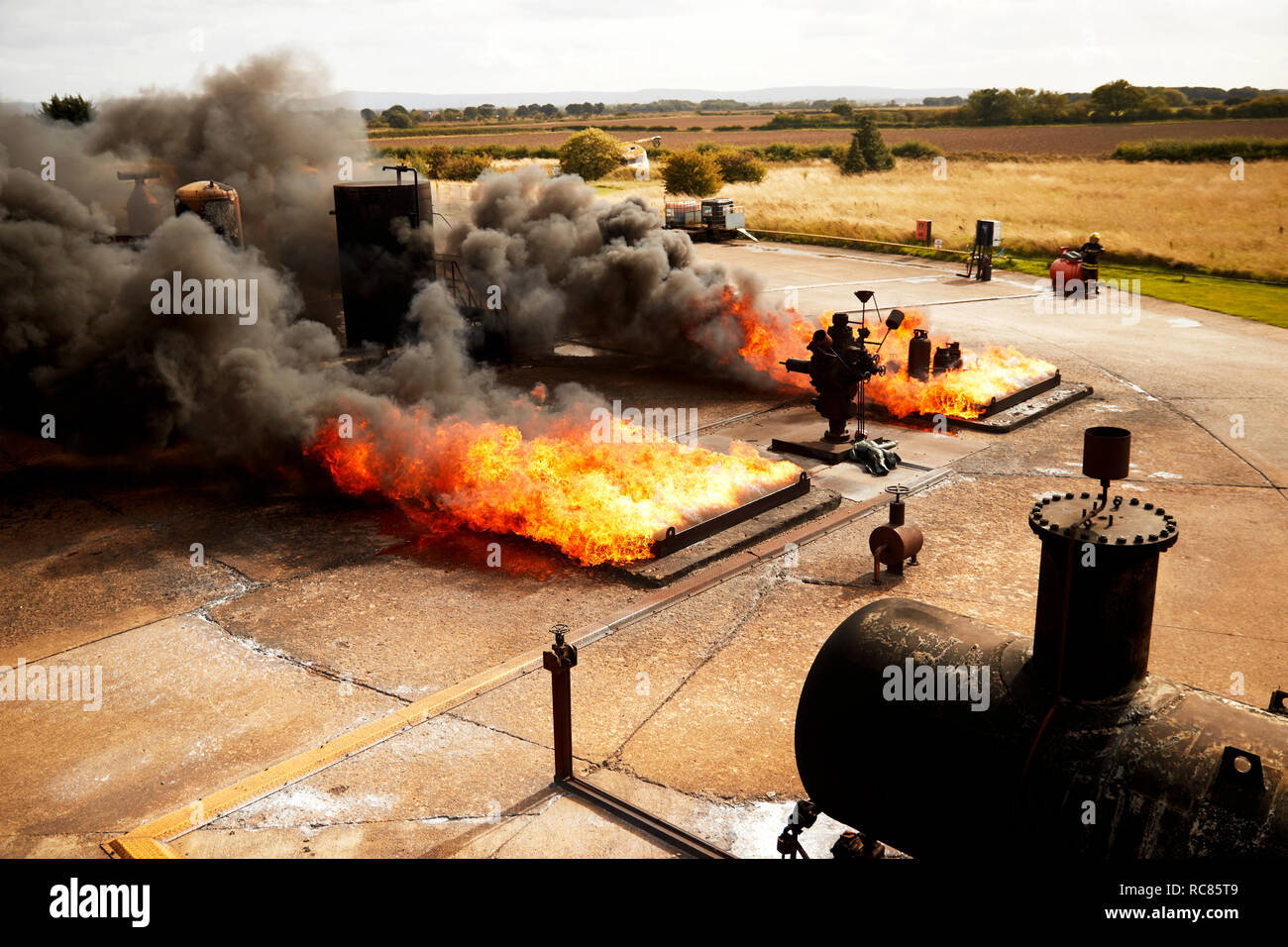 Firemen training, burning fires and smoke at training facility Stock Photo