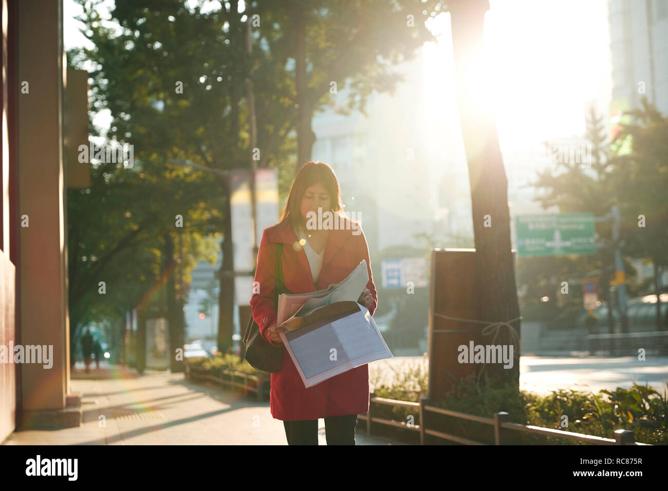 Businesswoman reading newspapers in city, Seoul, South Korea Stock Photo