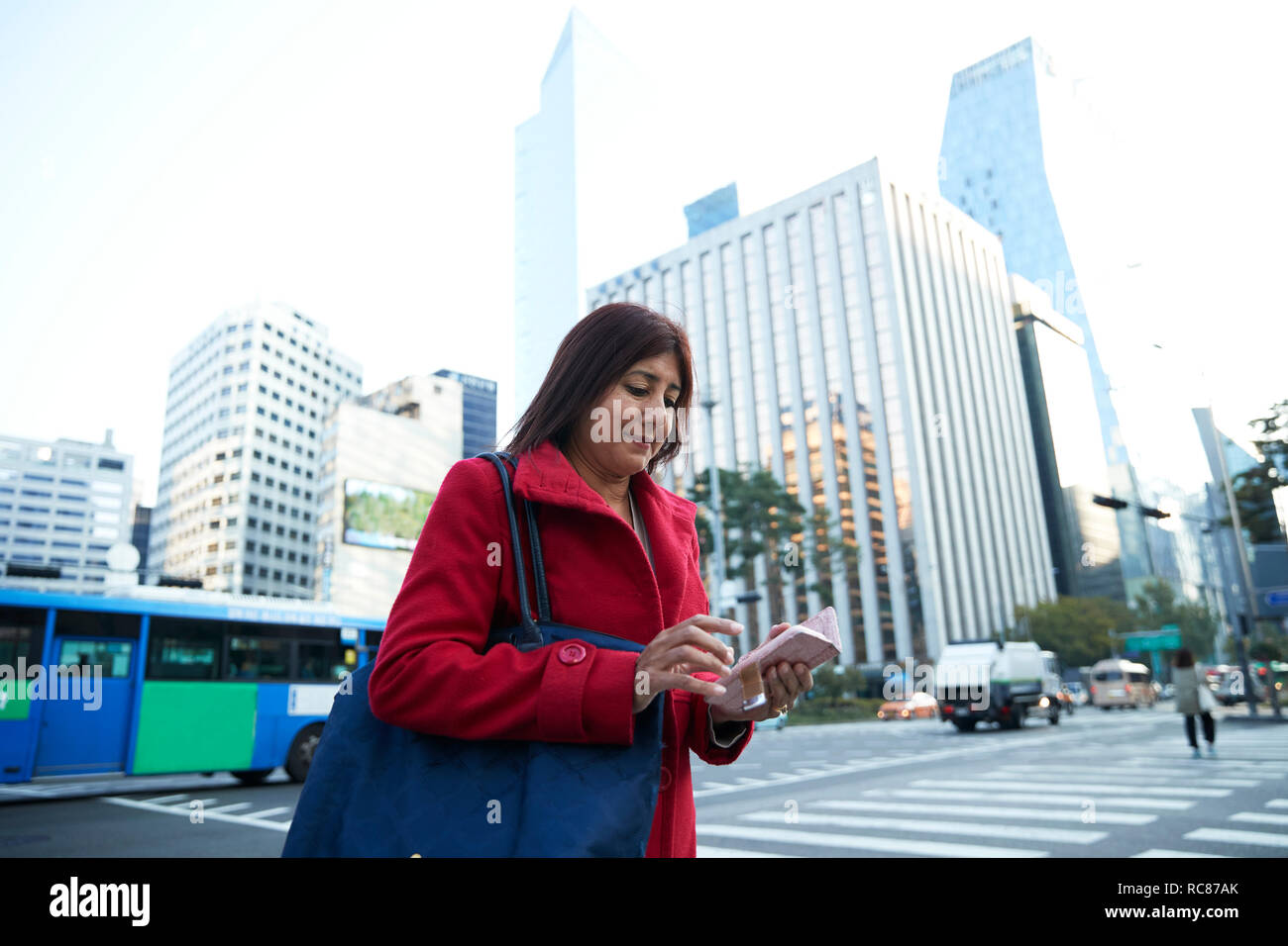 Businesswoman using smartphone in city, Seoul, South Korea Stock Photo