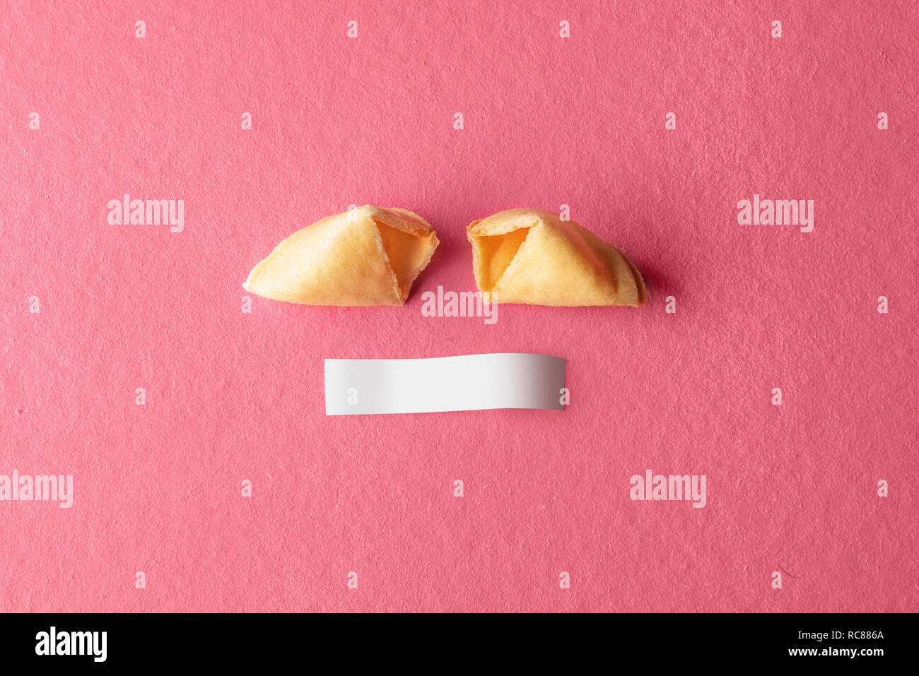Cracked fortune cookies with blank paper on the pink background Stock