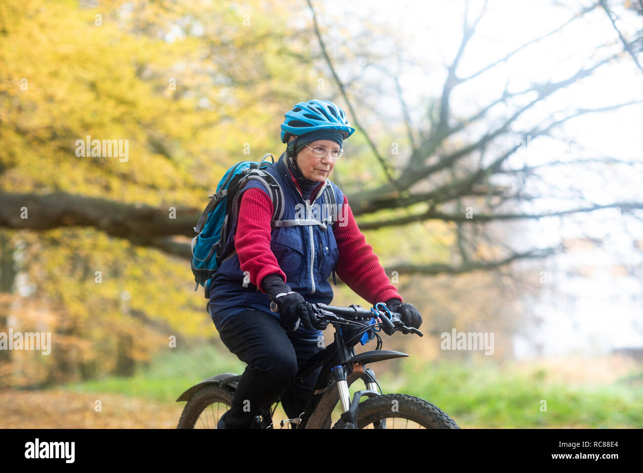 Senior woman cycling in park Stock Photo