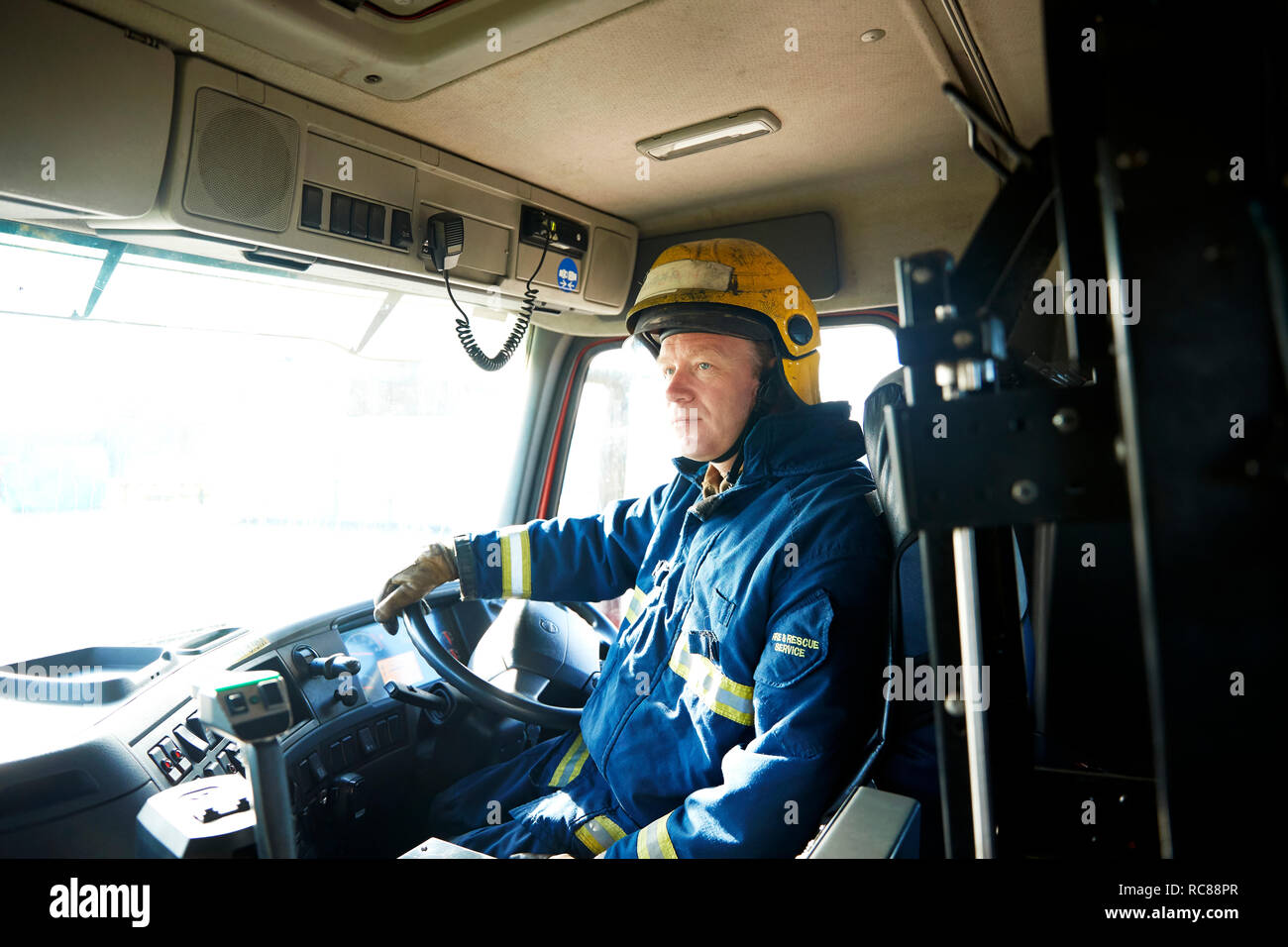 Fireman at wheel of fire engine Stock Photo