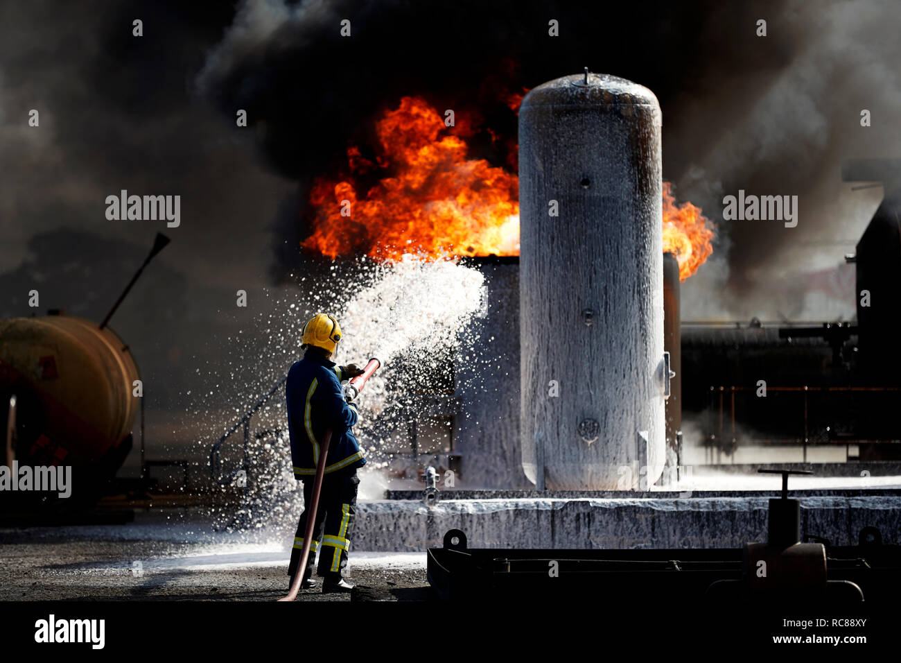 Fireman training to put out fire on burning tanks, Darlington, UK Stock Photo
