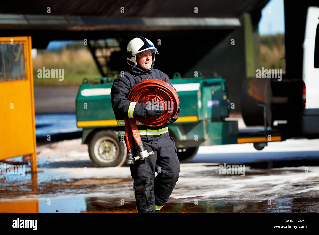 Fireman carrying fire hose reel, Darlington, UK Stock Photo