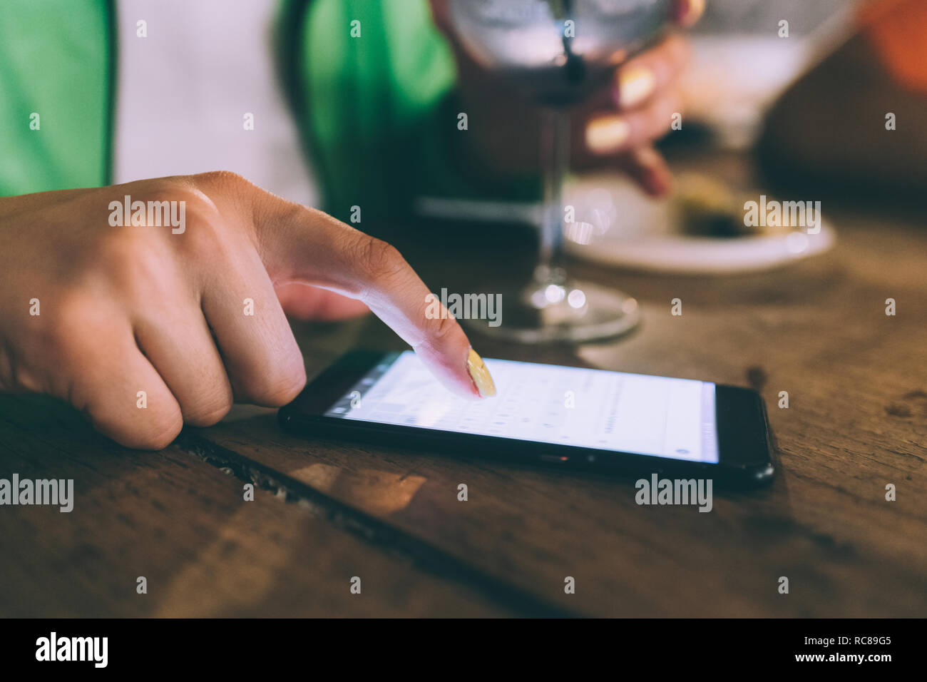 Woman texting and having drink in bar Stock Photo