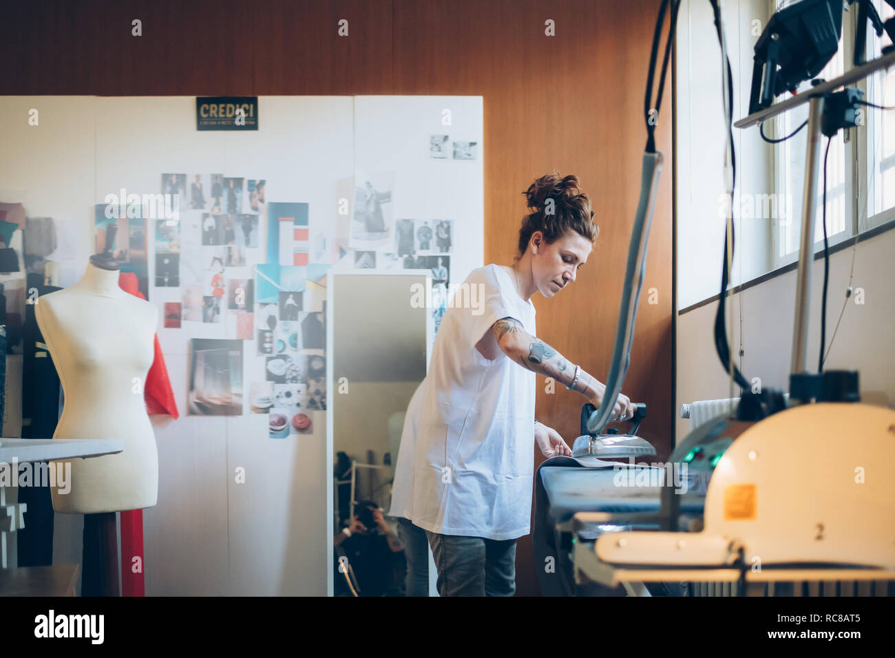 Fashion designer ironing in her work studio Stock Photo