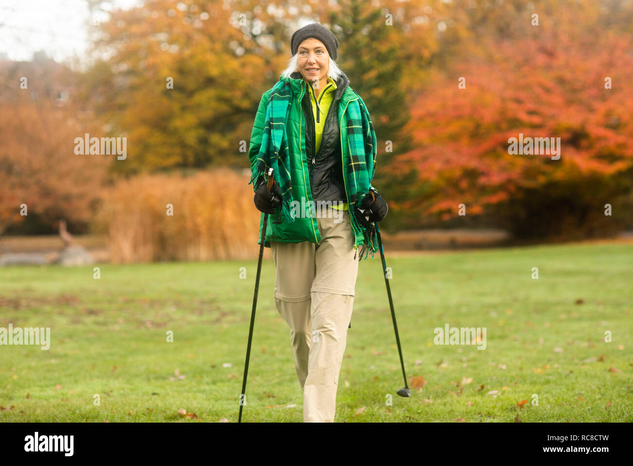 Mature woman nordic walking in park Stock Photo