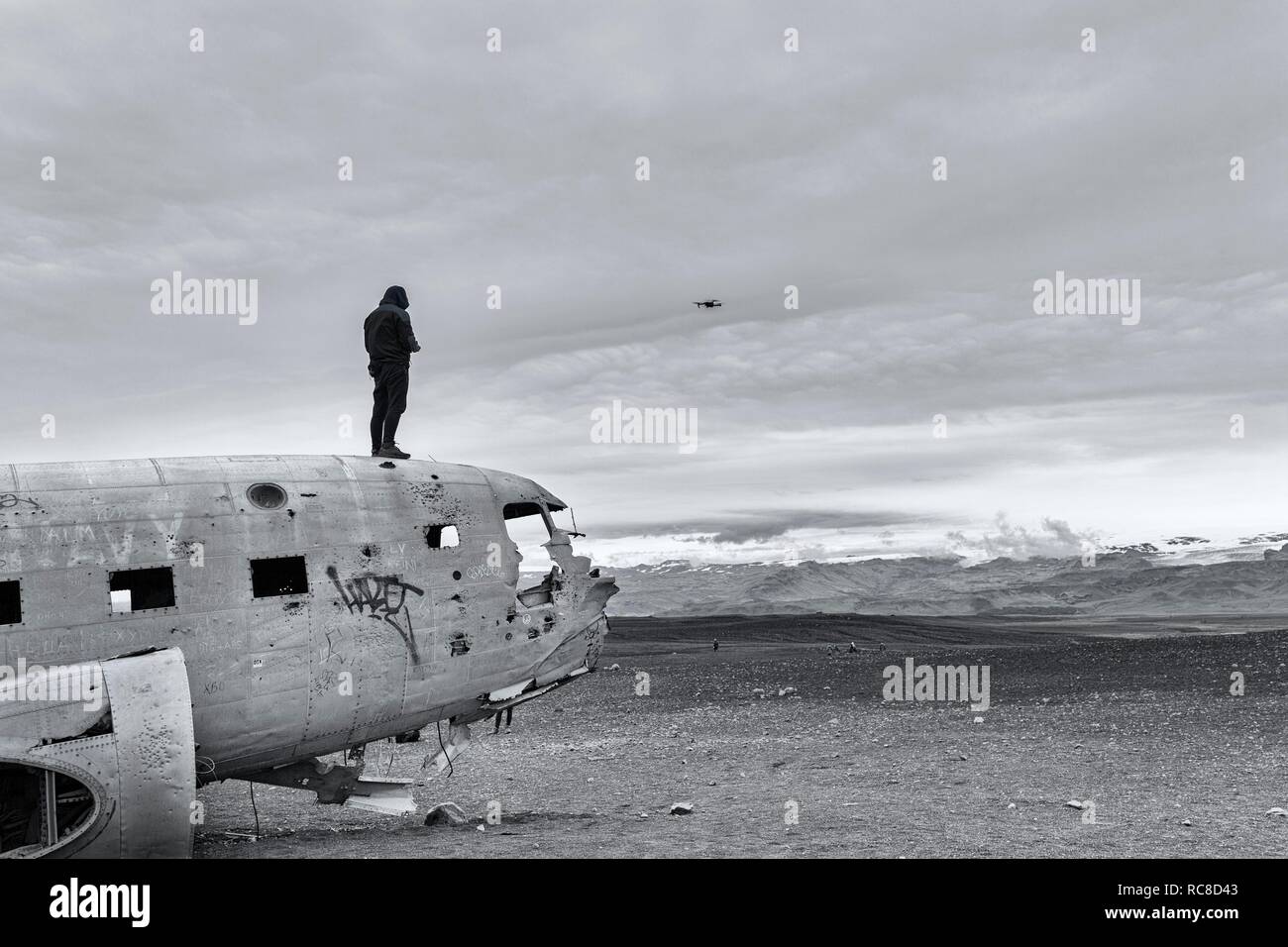 Man on aircraft wreck Douglas DC-3 controls Drone, Sólheimasandur, Solheimasandur, near Ring Road, Suðurland, Sudurland Stock Photo