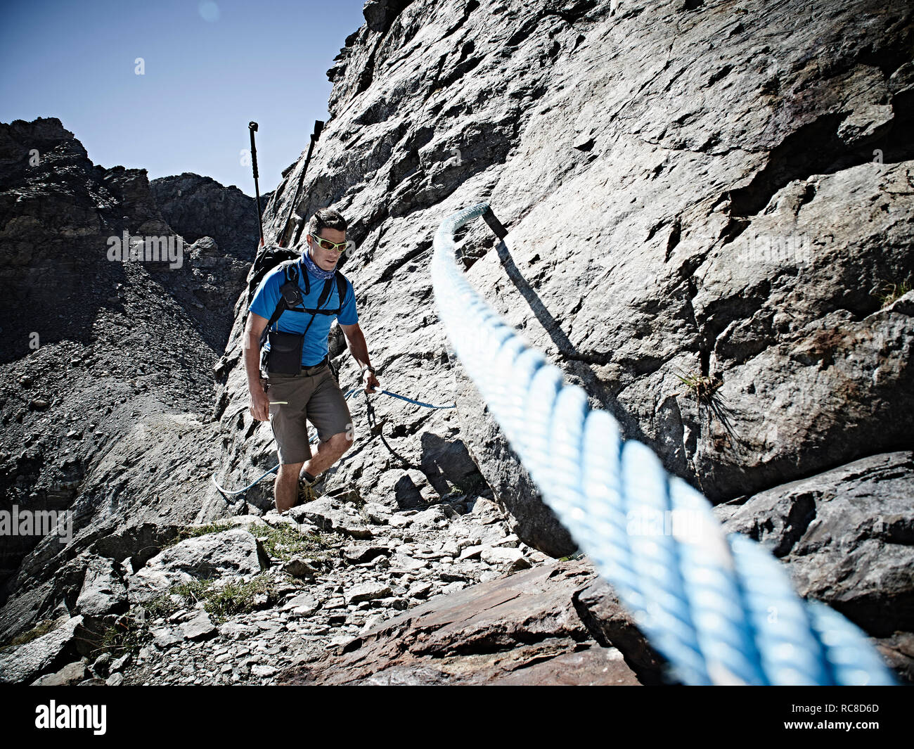 Hiker using rope to ascend rock face, Mont Cervin, Matterhorn, Valais, Switzerland Stock Photo