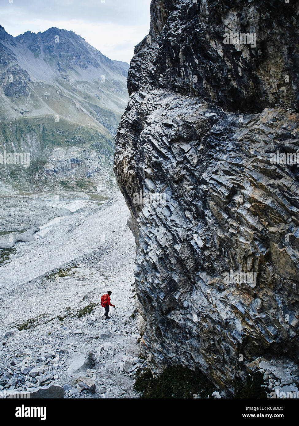 Hiker moving across rocky terrain, Mont Cervin, Matterhorn, Valais, Switzerland Stock Photo