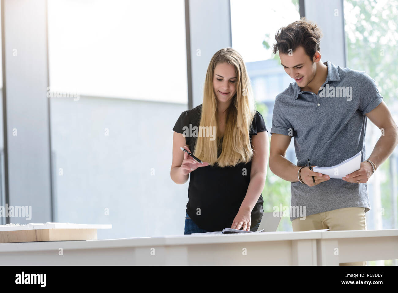 Colleagues brainstorming by glass wall Stock Photo