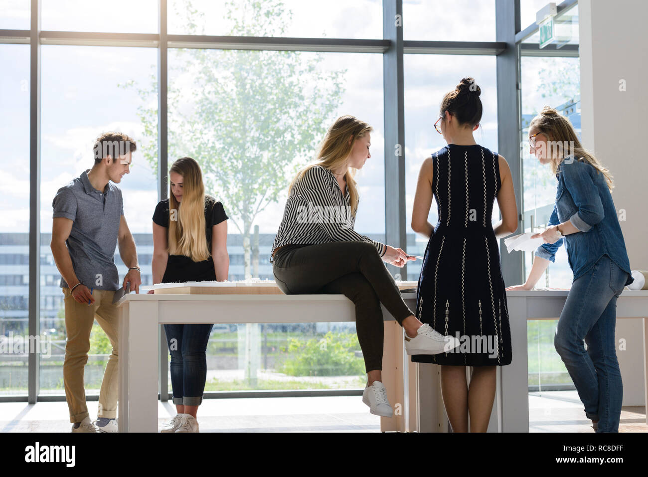 Colleagues brainstorming by glass wall Stock Photo