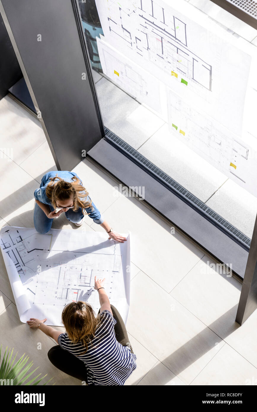 Colleagues brainstorming over plans Stock Photo