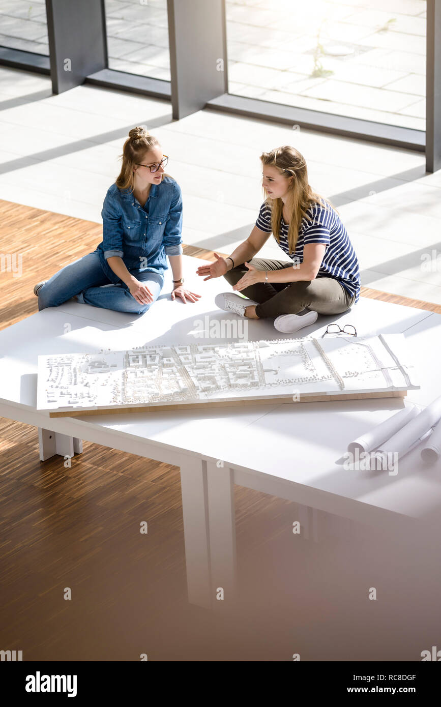 Colleagues brainstorming over architectural model Stock Photo