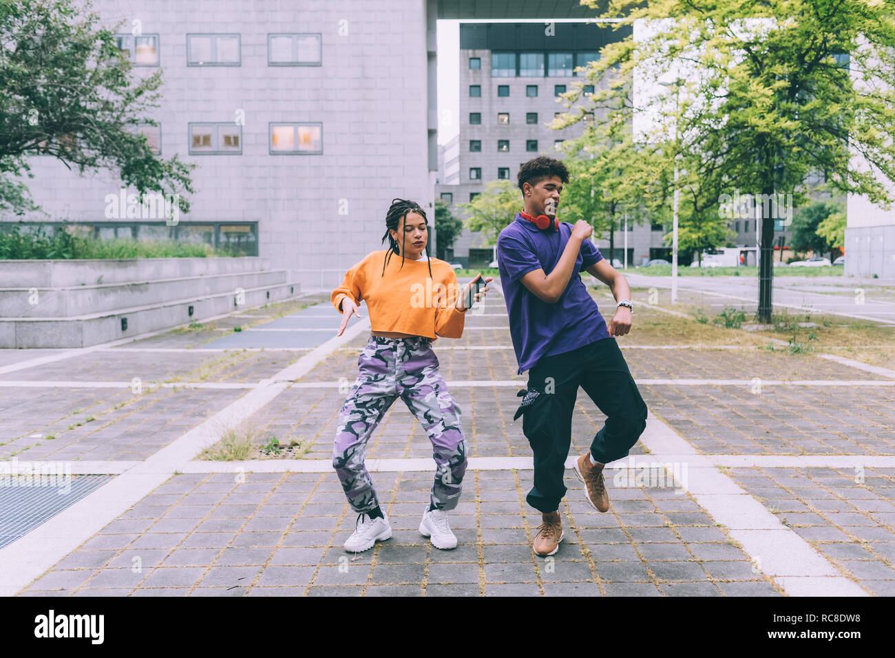 Brother and sister dancing to footage on mobile, Milan, Italy Stock Photo