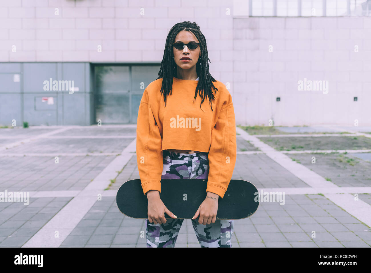 Woman with skateboard, Milan, Italy Stock Photo