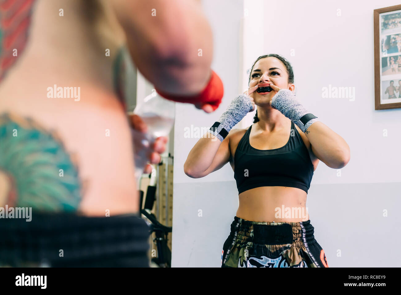 Female boxer putting on mouth guard Stock Photo