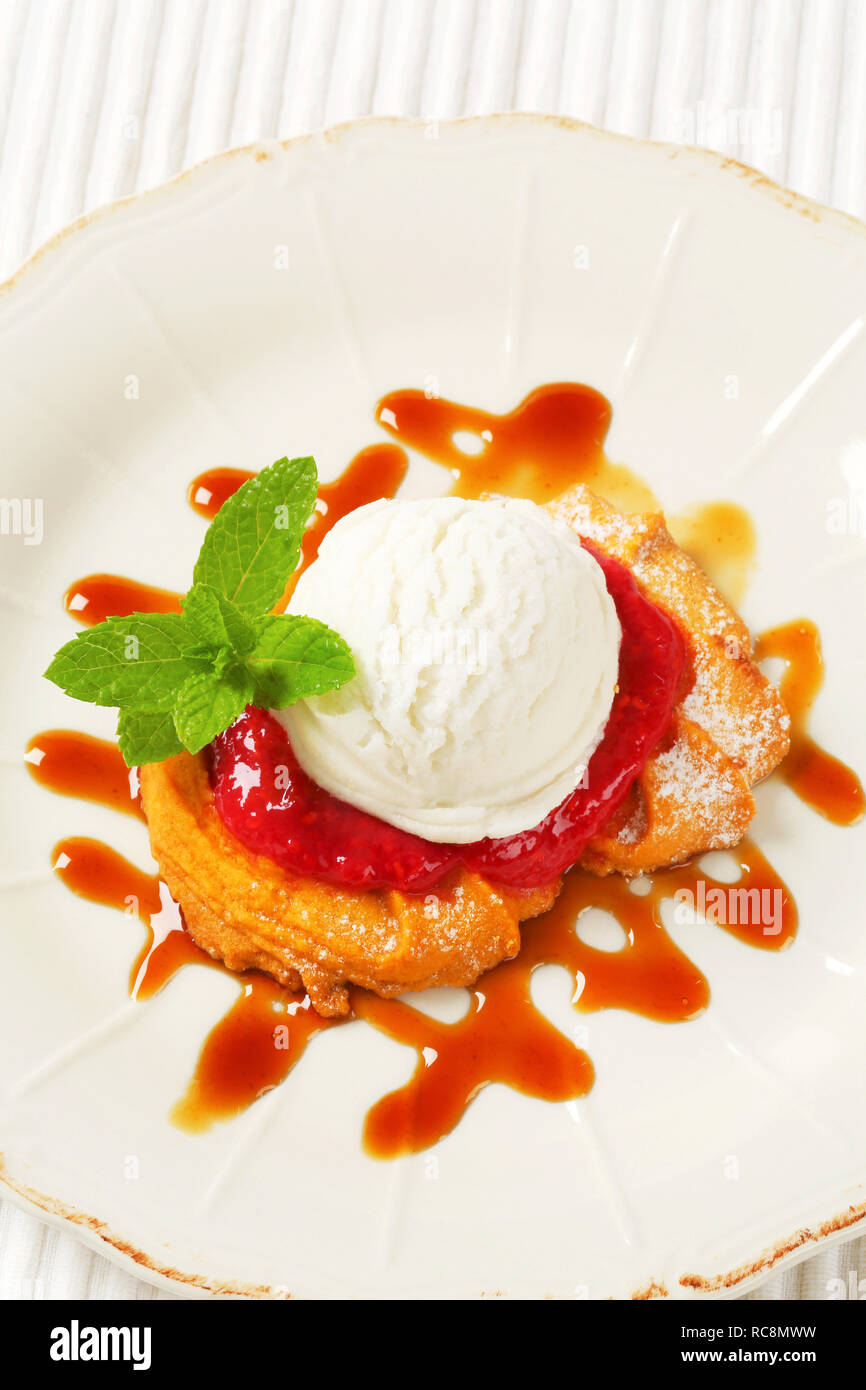 Spritz butter cookie with raspberry sauce and scoop of white ice cream Stock Photo