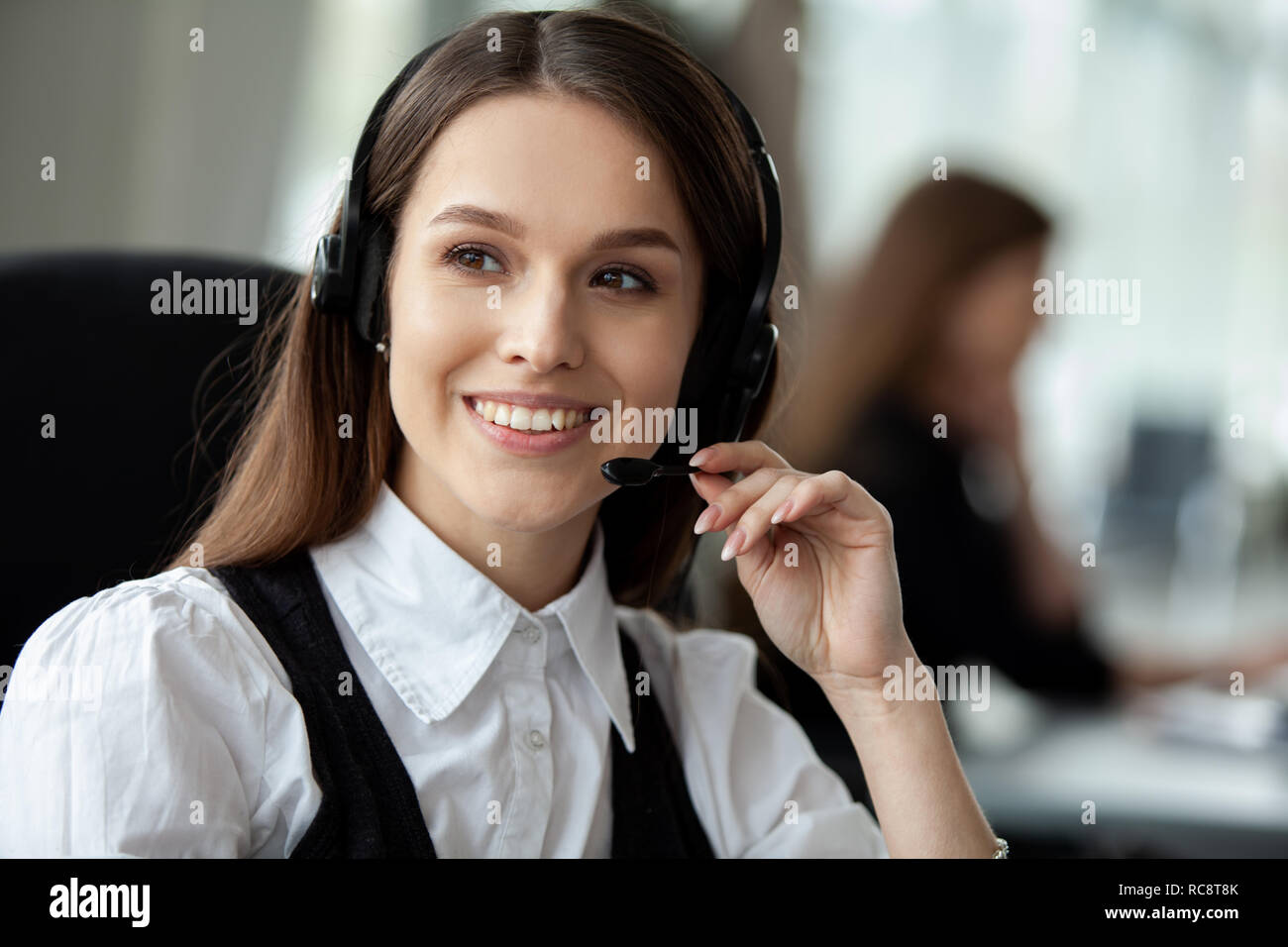 Female customer support operator with headset and smiling. Stock Photo